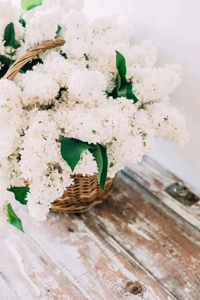 Boeket van verse witte lila bloemen in rieten mand op houten — Stockfoto