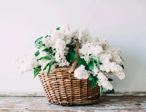 Buquê de flores lilás brancas frescas em cesta de vime em madeira — Fotografia de Stock