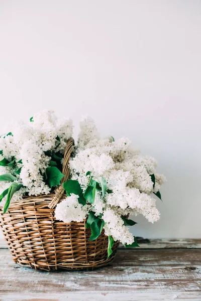 Boeket van verse witte lila bloemen in rieten mand op houten — Stockfoto