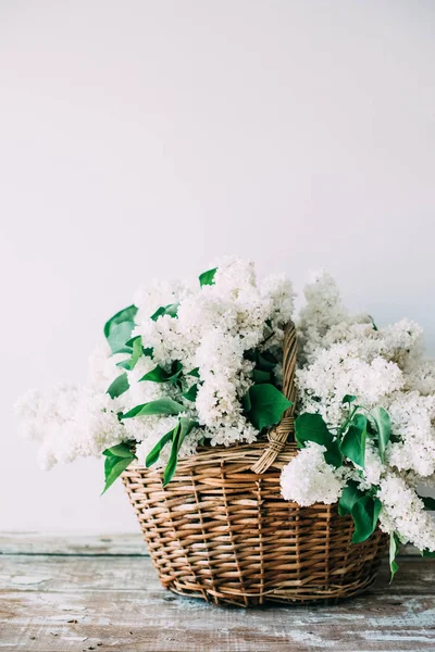 Ramillete de flores frescas de color lila blanco en canasta de mimbre sobre madera —  Fotos de Stock