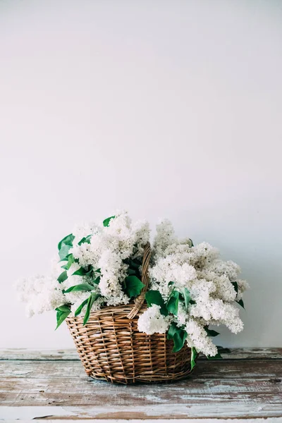 Ramillete de flores frescas de color lila blanco en canasta de mimbre sobre madera — Foto de Stock