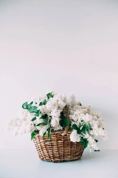 Buquê de flores lilás brancas frescas em cesta de vime em madeira — Fotografia de Stock