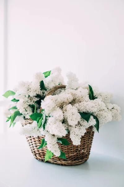 Buquê de flores lilás brancas frescas em cesta de vime em madeira — Fotografia de Stock