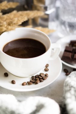 Yatakta beyaz fincanda sade kahve.