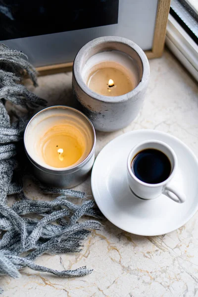 Brennende Kerzen, graue Decke und eine Tasse Kaffee — Stockfoto