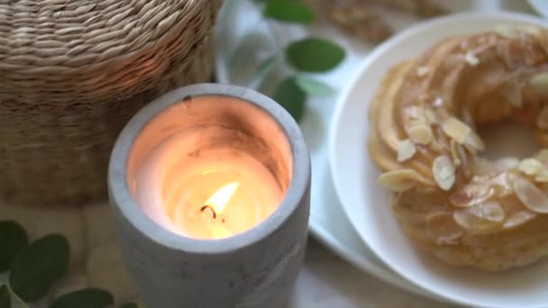 Acogedor desayuno en casa con taza de café, pastel de crema y velas encendidas — Vídeos de Stock