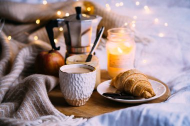 Sıcak kış hafta sonu kahvaltısı, ahşap tepside kahve ve kruvasan