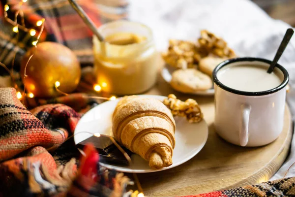 Jednoduchá domácí snídaně v posteli, káva s mlékem a domácí pečivo na kostkované přikrývce — Stock fotografie