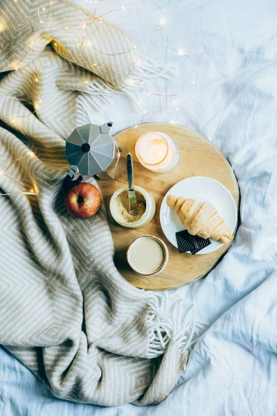 Acogedor desayuno de fin de semana de invierno, café y croissant en bandeja de madera — Foto de Stock
