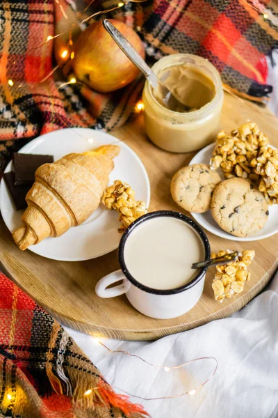 Basit bir köy kahvaltısı yatakta, sütlü kahve ve ekose battaniyeli ev yapımı pasta. — Stok fotoğraf