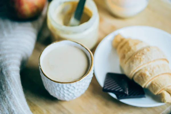 Aconchegante fim de semana de inverno café da manhã, café e croissant na bandeja de madeira — Fotografia de Stock