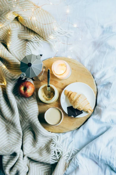 Затишний сніданок на зимових вихідних, кава і круасан на дерев'яному підносі — стокове фото