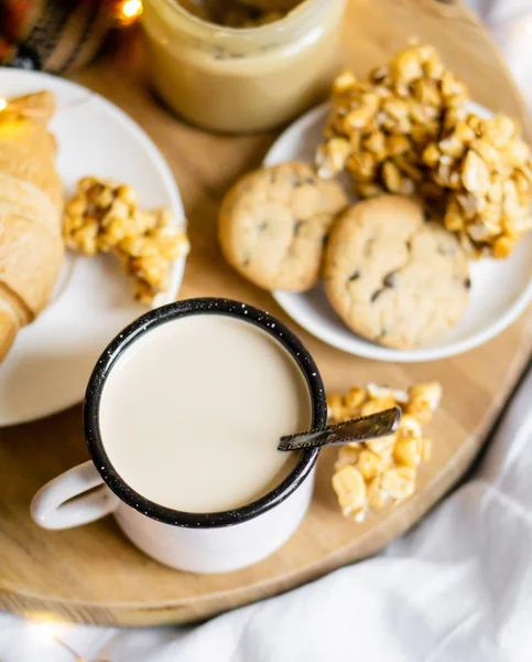 Semplice colazione casalinga a letto, caffè con latte e pasticceria fatta in casa su coperta a quadri — Foto Stock