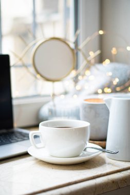 Rahat serbest çalışanlar, kışlık iş yerlerinde bir fincan kahveyle birlikte.