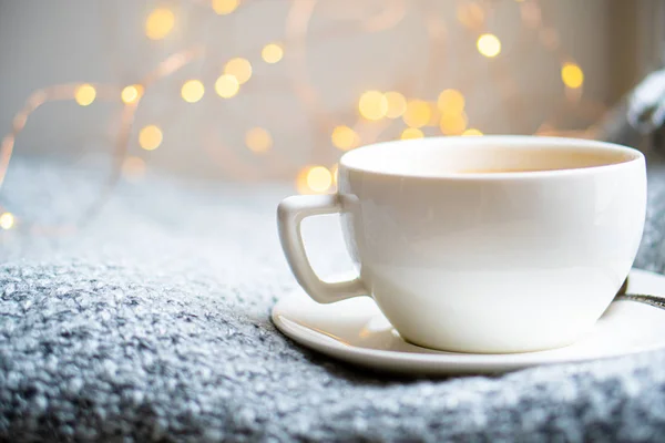 Taza de café con leche en una acogedora manta de invierno de punto — Foto de Stock