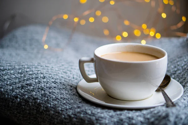 Taza de café con leche en una acogedora manta de invierno de punto — Foto de Stock