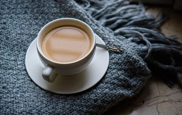 Sıcak örülmüş kış battaniyesinde sütlü bir fincan kahve. — Stok fotoğraf