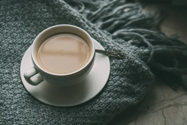 Cup of coffee with milk on cozy knitted winter blanket — Stock Photo, Image