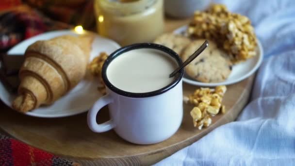 Basit bir köy kahvaltısı yatakta, sütlü kahve ve ekose battaniyeli ev yapımı pasta. — Stok video