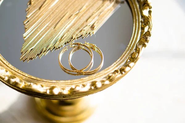 Gouden oorbellen en ketting op spiegel lade — Stockfoto