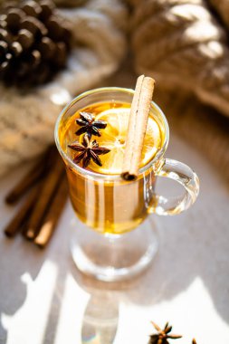 Hot winter drink with cinnamon and lemon on bright sunny day