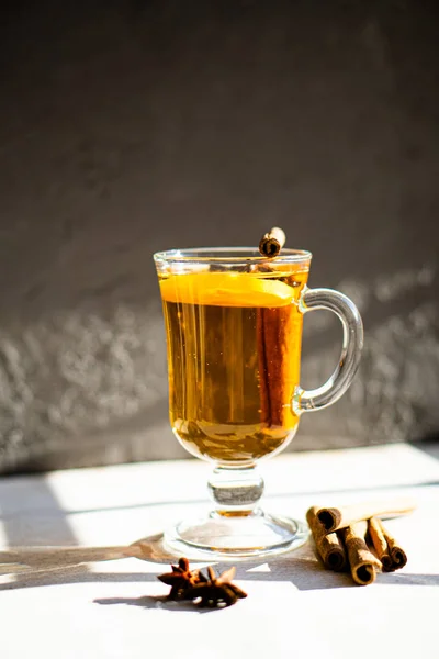 Hot winter drink with cinnamon and lemon on bright sunny day — Stock Photo, Image