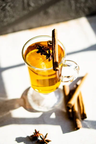 Hot winter drink with cinnamon and lemon on bright sunny day — Stock Photo, Image