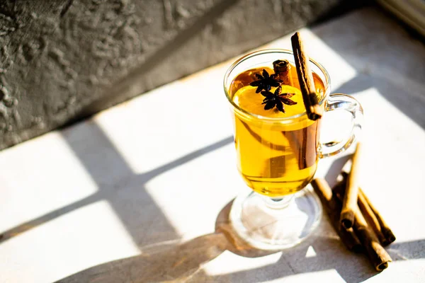 Hot winter drink with cinnamon and lemon on bright sunny day — Stock Photo, Image