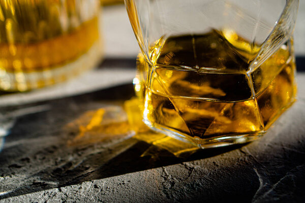 Whiskey in glasses on table in bright sunlight, yellow drink