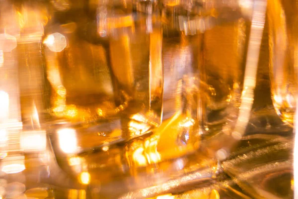 Beautiful bokeh and light reflections in yellow glass perfume bottles — Stock Photo, Image
