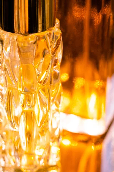 黄色のガラス香水ボトルの美しいボケと光の反射 — ストック写真
