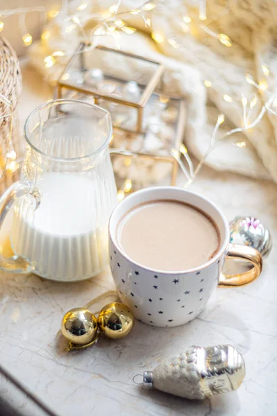 Acogedora decoración de vacaciones de invierno, luces de Navidad y taza de café con detalles de decoración, hogar real — Foto de Stock