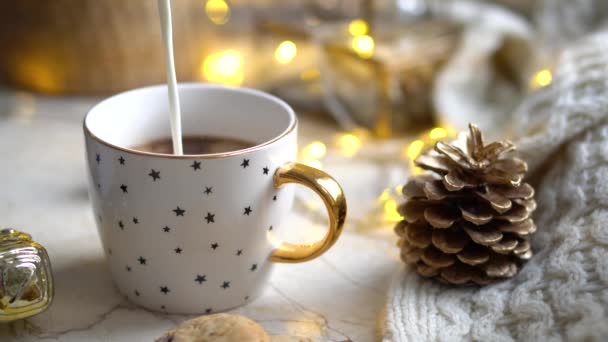 Frische Milch gießt in Kaffeetasse, gemütliche Winterdekoration — Stockvideo