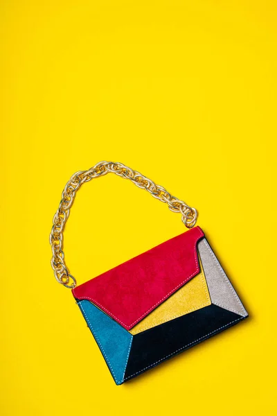 Colorful ladys bag, womans purse on yellow flat background