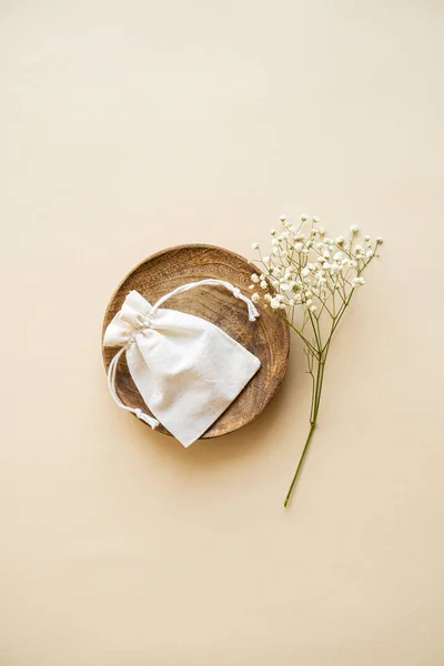 Bolso de lino pequeño en placa de madera sobre fondo beige — Foto de Stock