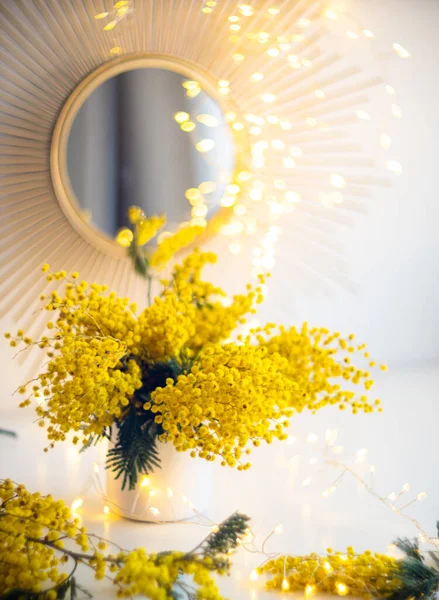 Bouquet of yellow mimosa flowers with bright gold interior decor with light spots — Stock Photo, Image