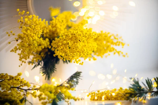 Bouquet of yellow mimosa flowers with bright gold interior decor with light spots — Stock Photo, Image