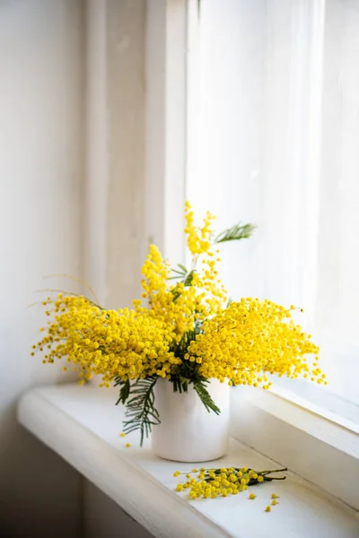Bouquet of yellow mimosa flowers on white vintage windowsill, retro interior — Stock Photo, Image