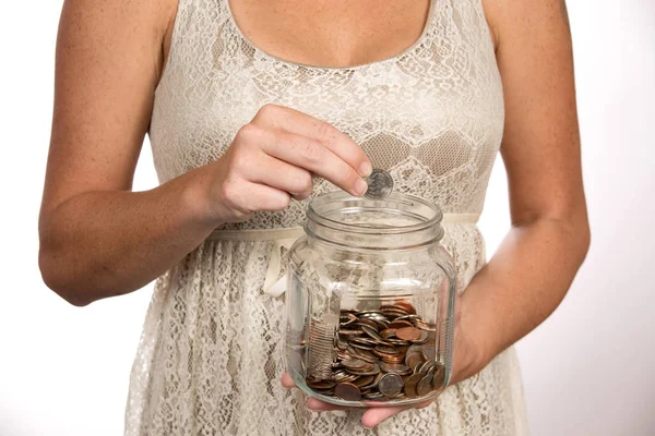 Mujer poniendo dinero en frasco de ahorros — Foto de Stock