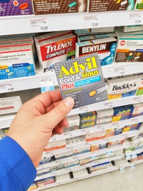 Montreal, Kanada - 10 Mart 2018: Ağrı kesici paketi tutan bir el. Steroid olmayan anti-inflamatuar ilaç NSAİİ ağrı kesici ibuprofen olduğunu