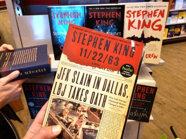 Stephen King 'in 122-63 numaralı kitabını tutan bir el.