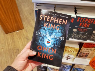 Stephen King 'in Uyuyan Güzeller kitabını tutan bir el.