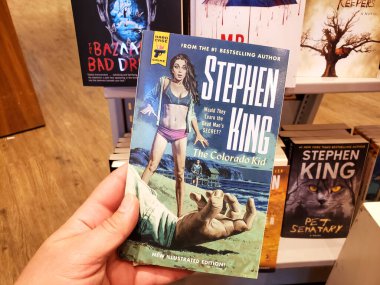 Stephen King 'in kitabı Colorado Kid' i tutan bir el.