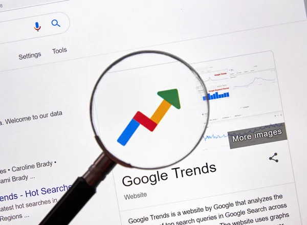 Google Trends web site and logo under magnifying glass — 스톡 사진