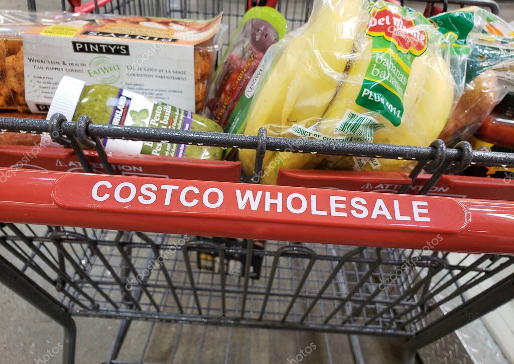 MONTREAL, CANADA - APRIL 6, 2019: Costco wholesale cart with groceries in Costco warehouse. Costco is an American corporation which operates a chain of membership only warehouses.