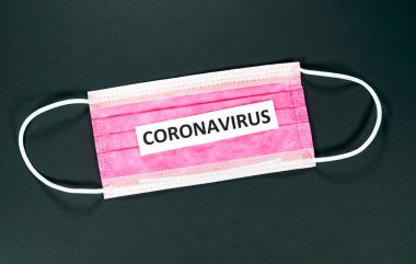 Coronavirus siyah arka planda kırmızı bir maske takıyor. Coronavirus nedir? Yeni bir koronavirüs, daha önce tanımlanmamış yeni bir koronavirüstür. Virüs COVID-19 hastalığına neden oluyor.