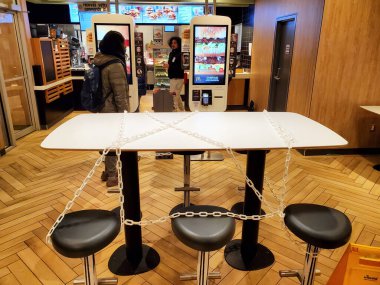 Montreal, Kanada - 22 Mart 2020: Coronavirüs nedeniyle McDonalds 'da sandalyeler ve masalar zincirli. Birçok restoran ve fast food restoranları insanların oturmasını engellemek için masalara ve koltuklara zincir takıyor.