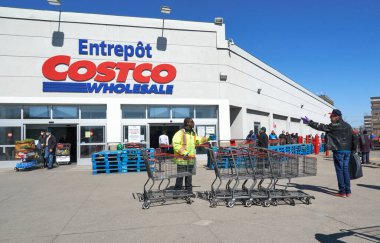 Montreal, Kanada - 4 Nisan. 2020: Maskeli insanlar Costco toptan satışına girmek için sıraya girdiler. Pek çok mağaza, Coronavirus nedeniyle dükkana kuyruk girmesine neden olan sosyal uzaklık uygulaması uyguladı