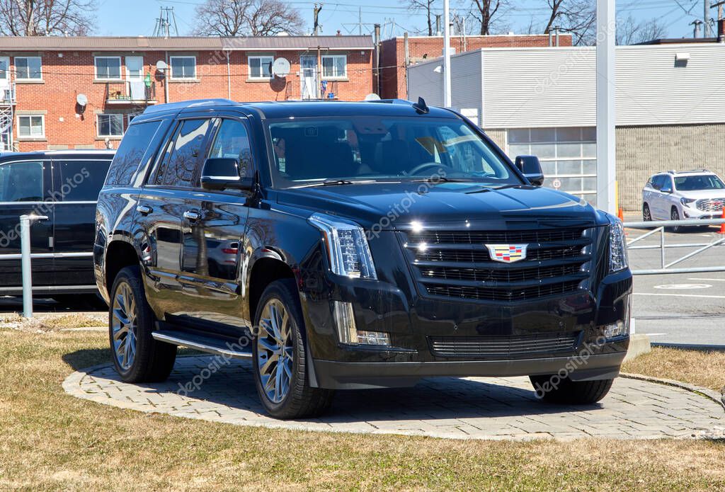 Montreal, Canada - April 4, 2020: Cadillac Escalade black car at dealership. Cadillac is a division of American automobile manufacturer General Motors GM that designs and builds luxury vehicles.
