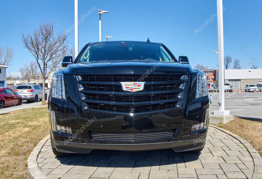 Montreal, Canada - April 4, 2020: Cadillac Escalade black car at dealership. Cadillac is a division of American automobile manufacturer General Motors GM that designs and builds luxury vehicles.